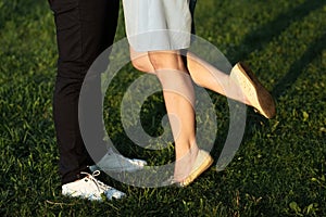 A young couple kissing in a backyard in summer sun light during sunset