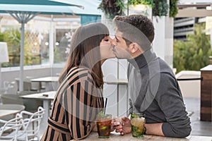 a young couple kissing at a bar terrace