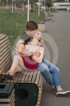 Young couple kissing at the bench on the street