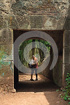 Young couple kissing in forest, romantic moment of couple in medieval arch. Couple vacation concept. Concept of love