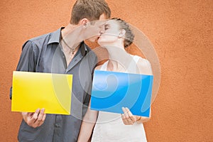 Young couple kissing and holding frames background