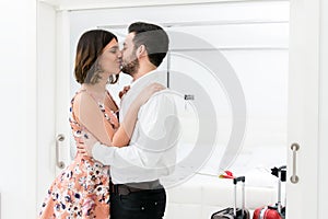 Young couple kissing in hotel suite.