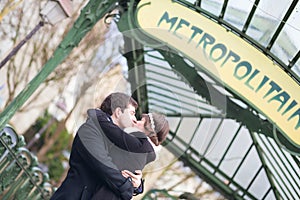 Young couple kissing near metro station in Paris