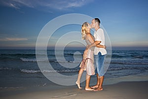 Young couple kissing near the ocean