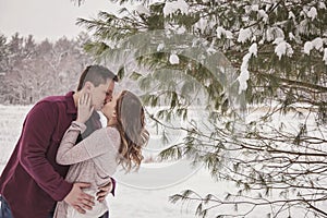 Young couple kissing outdoors in winter