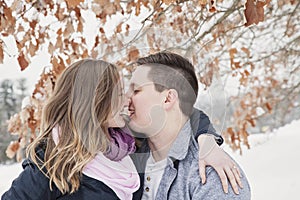 Young couple kissing outdoors in winter