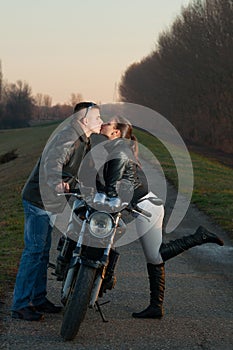 Young couple kissing over the motorcycle