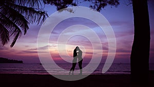 Young couple kissing on a romantic, tropical beach