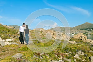 Young couple kissing on small mountain