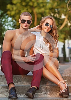 Young couple kissing with sunglasses outdoors