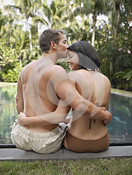 Young Couple Kissing BY Swimming Pool