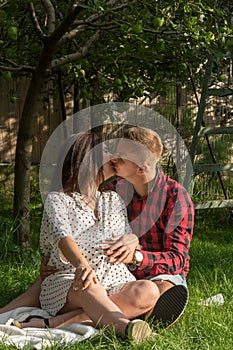 Young couple kissing under the trees in the garden