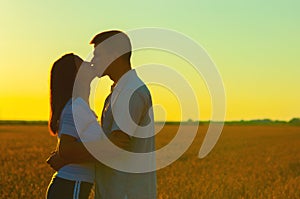 Young couple kissing on the wheat field