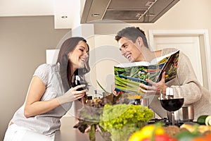 Young couple in kitchen with cookbook