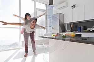 Young Couple In Kitchen, Lovers Hispanic Man Carry Asian Woman Modern Apartment