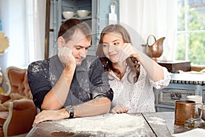 Young couple in the kitchen playing with flour. Funny moments, smiles, cooking, Happy together, memories.
