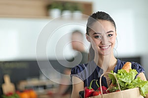 Young couple in the kitchen , woman with a bag of groceries shopping