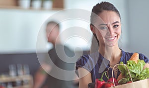 Young couple in the kitchen , woman with a bag of groceries shopping