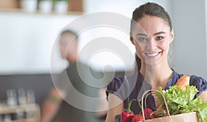 Young couple in the kitchen , woman with a bag of groceries shopping