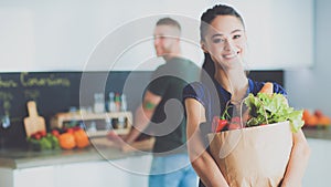 Joven en La cocina  una mujer bolsa de tienda de comestibles compras 