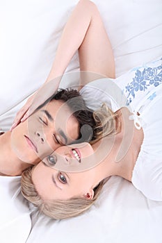 Young couple laid on a bed