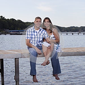 Young couple on lake pier
