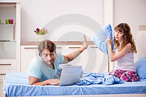 Young couple with laptop in the bedroom