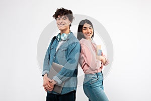 Young Couple With Laptop And Workbooks Posing On White Background
