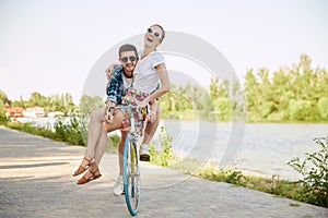 Young couple, laughing, joyful woman and her boyfriend going for a bike ride on a sunny summer day. love, people