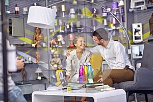 Young Couple Laughing and Shopping for Lighting Fixtures in a Store