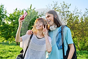 Young couple, laughing teenagers taking selfie photo on smartphone