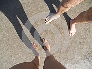 Young couple legs  standing on sand