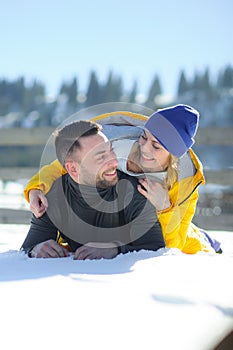 Young couple lies on snow.