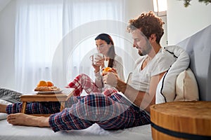 A young couple likes to have a breakfast in the bed. Love, relationship, together