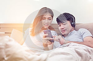 young couple listen to music in the bed