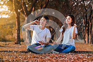 Couple listening music from mobile with headphone in the park