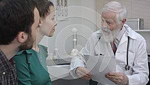 Young couple listening to mature doctor who tells them results of the research.