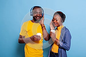 Young couple listening to music playlist on headphones