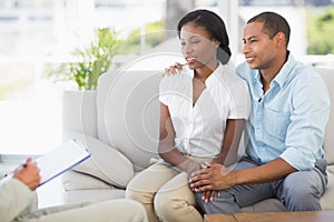 Young couple listening to salesman on the couch photo