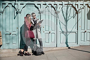 Young couple looking at book in the street