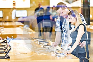 Young couple looking at displayed latest tablets