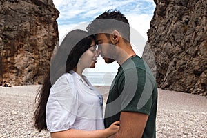 Young couple looking each other in a canyon in front of the sea. close-up