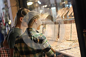 Young couple looking at jewelry through the window