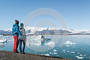 Young couple looking at Jokulsarlon glacier lake in Iceland