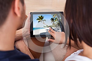 Young couple looking photos on digital tablet together