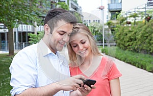 Young couple looking for pictures on the phone