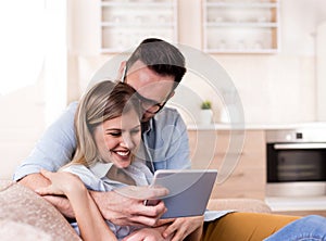 Young couple looking at tablet at home