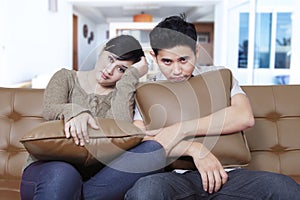 Young couple looks bored on the sofa