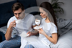Young couple in loungewear drinking coffee photo