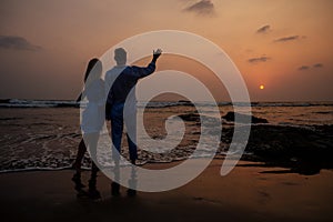 Young couple in love on the beach February 14, St. Valentine`s Day sunset Goa India vacation trip .travel new year in a